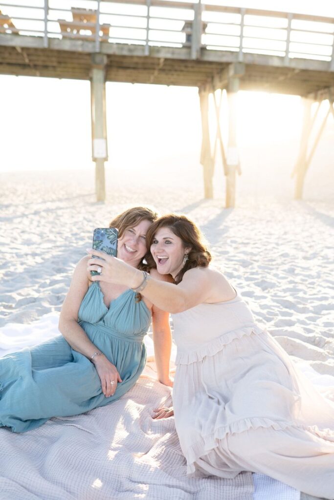 Meet the team behind Printed Hues, watercolor artistry taking a selfie on the beach in Wilmington, North Carolina