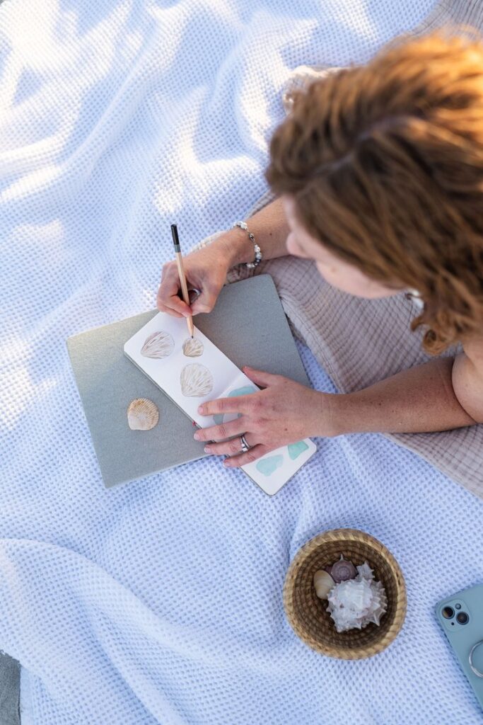 Meet Laura, a local watercolor artist painting on a beach blanket in Wilmington, North Carolina