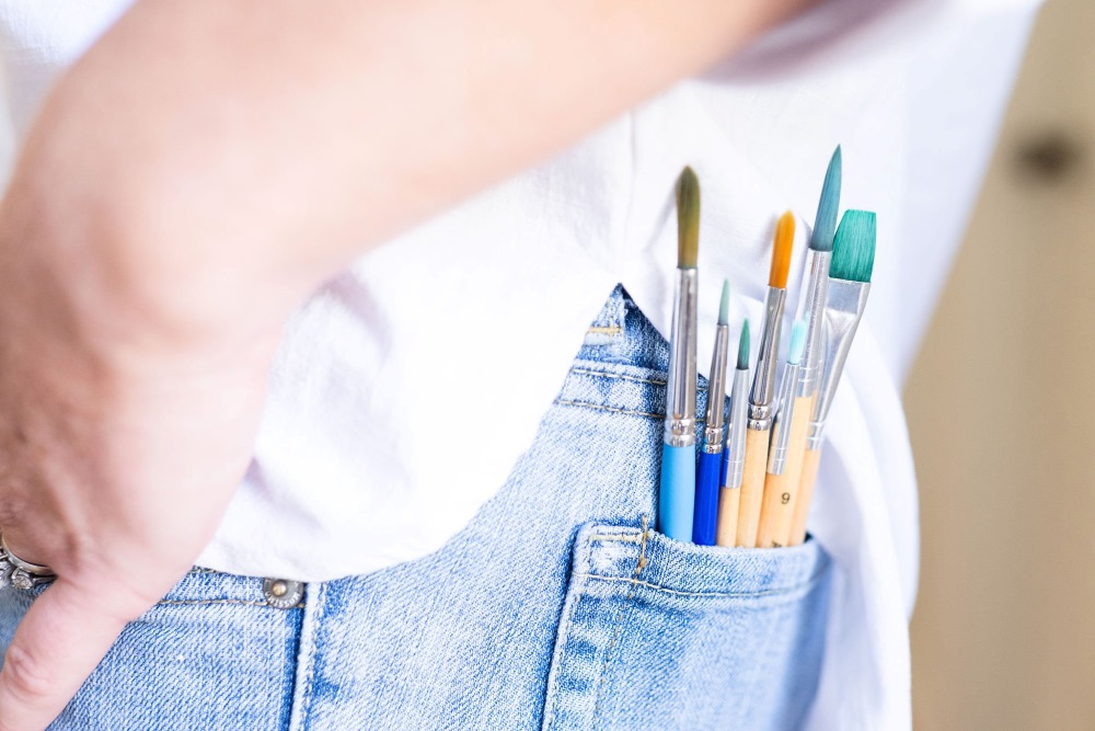 The back pocket of a watercolor artist filled with paint brushes in Wilmington, North Carolina