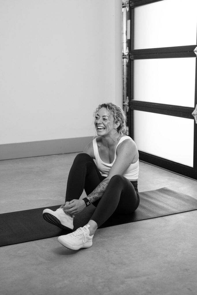 A branding photoshoot for a female fitness and health coach sitting on a yoga mat.