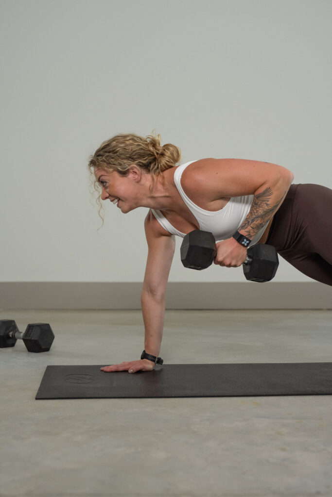 A branding photoshoot for a female fitness and health coach lifting dumbbells.