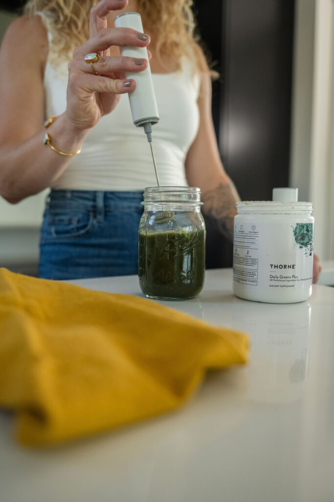 A branding photoshoot in a modern, moody kitchen for a female fitness and health coach.