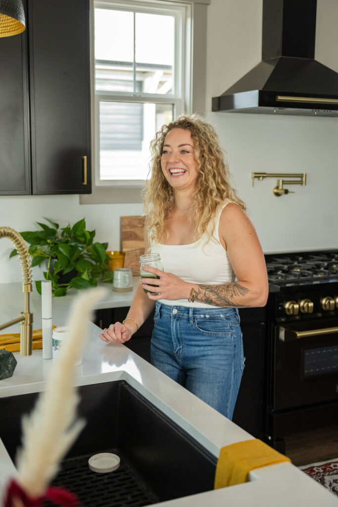 A branding photoshoot in a modern, moody kitchen for a female fitness and health coach.