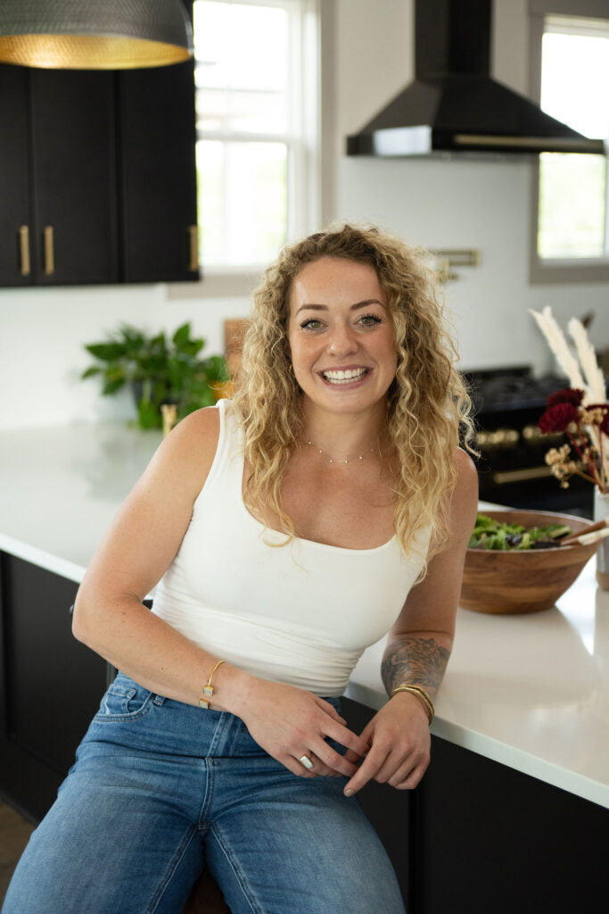 A branding photoshoot in a modern, moody kitchen for a female fitness and health coach.