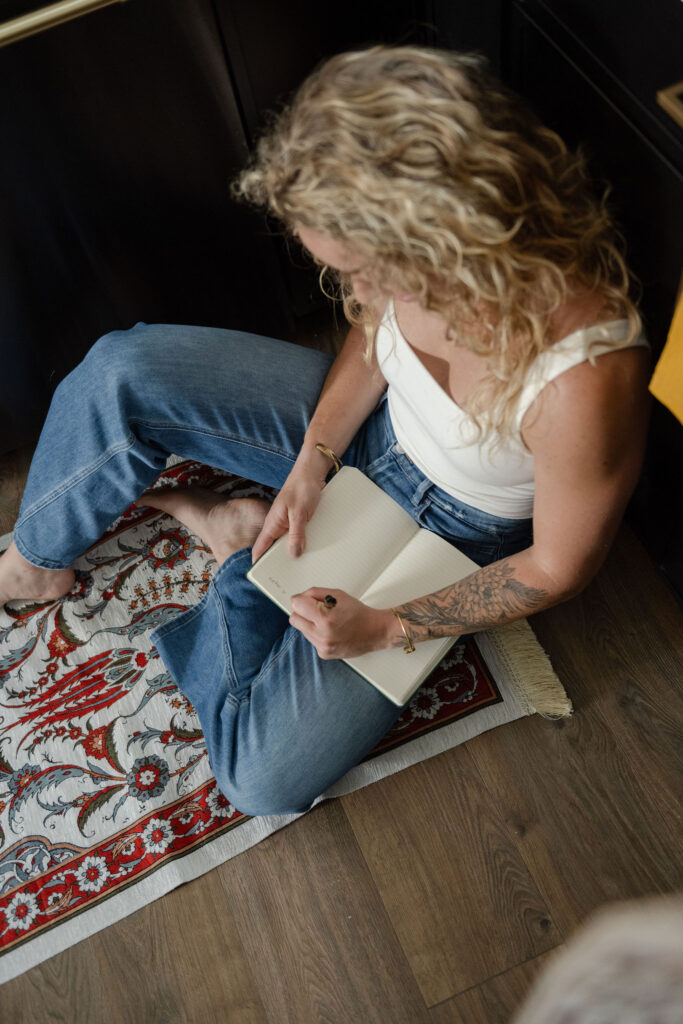 A branding photoshoot for a female fitness and health coach writing in a journal.