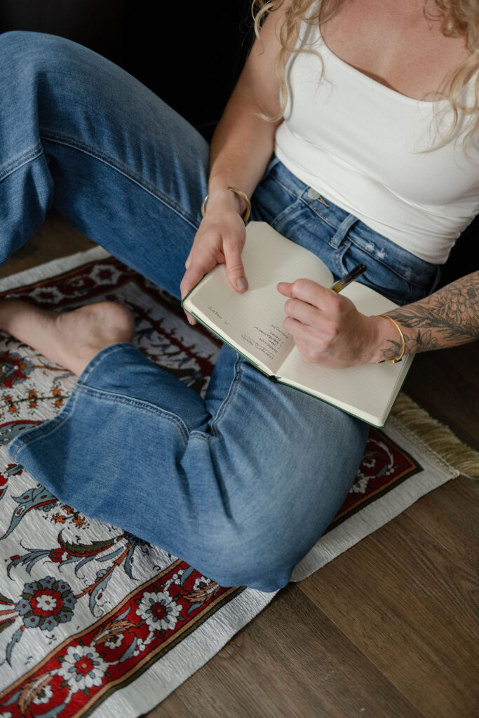 A branding photoshoot for a female fitness and health coach writing in a journal.