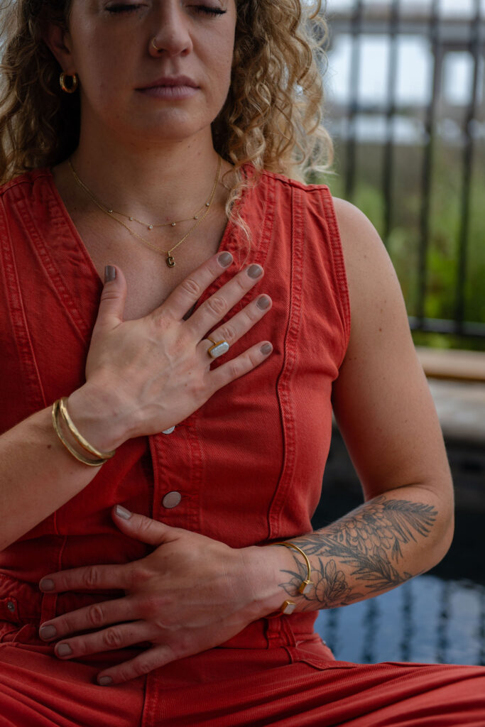 A branding photoshoot for a female fitness and health coach meditating by the pool.